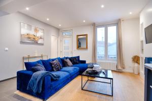 a blue couch in a living room with a table at Welcome to Luxyvibe in Vigneux-sur-Seine