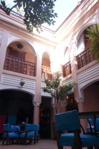 a building with blue chairs in a courtyard at Riad Turquoise in Marrakech