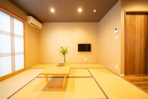a living room with a table and a tv at Hisaya-Totoya-A in Kyoto