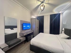 a hotel room with a bed and a television at Nabatean Hearth Guest House in Taiyiba