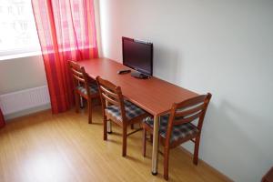 a wooden table with chairs and a television on it at Sports Centre Haapsalu in Haapsalu +14 photos