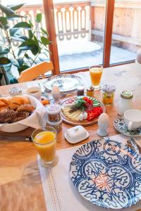 a table with breakfast foods and orange juice on it at Ecologie Grundlsee in Grundlsee