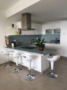 a kitchen with a counter with stools and a sink at NEW Apartment with sunset views and pool in Żebbuġ