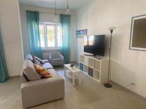 a living room with a couch and a flat screen tv at il posto giusto - the right place in Anzio