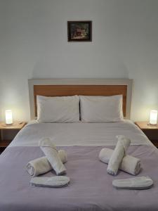 a bed with two pairs of towels on top of it at EstellApartments in Athens