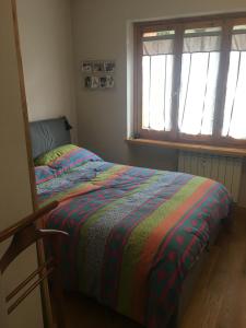 a bedroom with a bed with a colorful blanket at Cozy apartment with private garden, 2 bedrooms in Sauze d'Oulx
