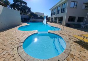 Una gran piscina azul al lado de un edificio en Hello Holiday-Banana Beach Club D17, en Melville