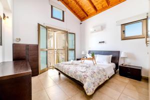 Un dormitorio con una cama, un escritorio y ventanas. en Kymma River Villa #4, en Ayia Napa