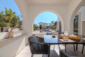 Un comedor con mesa y sillas en un balcón. en Kymma River Villa #4, en Ayia Napa