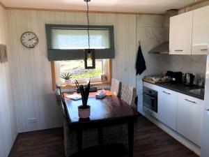 a kitchen with a table and a clock on the wall at BB Saari in De Woude