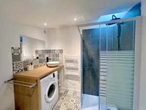 a bathroom with a washing machine and a shower at La Tropézienne, charme et confort au coeur du Gard in Saint-Géniès-de-Malgoirès +3 photos