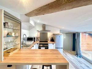 a kitchen with a wooden table in a room at La Tropézienne, charme et confort au coeur du Gard in Saint-Géniès-de-Malgoirès