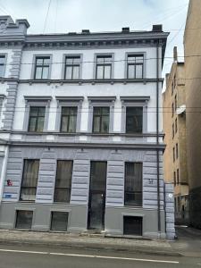 a white building with many windows on a street at Room for rent at Centre, Riga in Riga