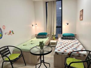 a room with two beds and a table and chairs at Room for rent at Centre, Riga in Riga