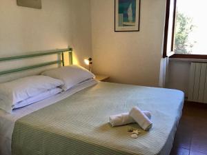 1 cama con toalla y 2 almohadas en Villetta, en San Vincenzo