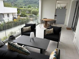 a balcony with a couch and chairs and a table at IseoLakeRental - Incanto Blu in Clusane sul Lago
