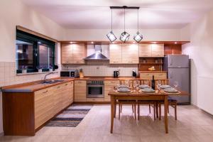 a kitchen with a wooden table and a refrigerator at Serenity Escape in Nísos Ródos