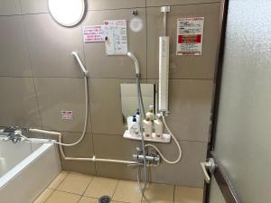 a shower in a bathroom with a bath tub and a sink at ホテル キラリ in Tottori +7 photos
