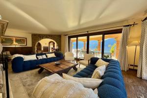 a living room with blue couches and a table at Villa Isola Verde in Valsolda