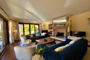 a living room with blue couches and a fireplace at Villa Isola Verde in Valsolda