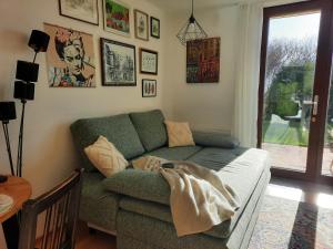 sala de estar con sofá verde y ventana en Gallery - Terrasse mit Seeblick und Garten, en Altmünster