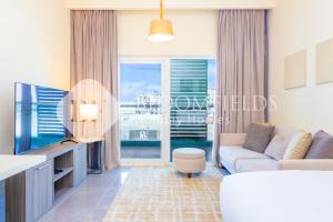 阿布扎比Bloomfields Cozy Stu with Balcony Leonardo的带沙发和电视的客厅