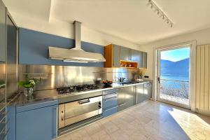 a kitchen with stainless steel appliances and a large window at Villa Isola Verde in Valsolda