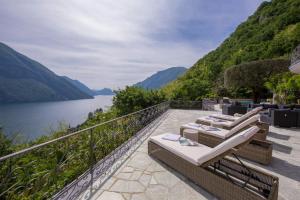 a balcony with chairs and a view of a lake at Villa Isola Verde in Valsolda
