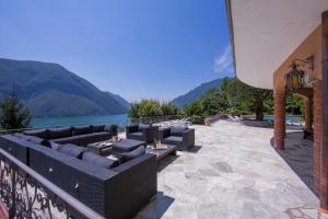 a patio with couches and a view of a lake at Villa Isola Verde in Valsolda