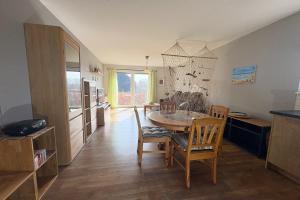 een keuken en eetkamer met een tafel en stoelen bij Cölpinstrasse Ferienwohnung Ostseeblume in Kolpinsee