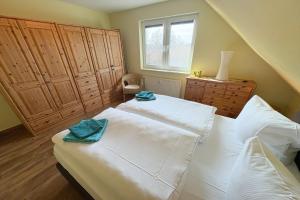 een slaapkamer met een groot wit bed en een raam bij Cölpinstrasse Ferienwohnung Ostseeblume in Kolpinsee