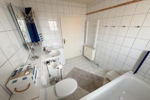 een badkamer met toilet, wastafel en bad bij Cölpinstrasse Ferienwohnung Ostseeblume in Kolpinsee +17 foto's