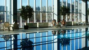 a swimming pool with people sitting next to a building at Jinjiang Fuyuan Hotel in Daxing