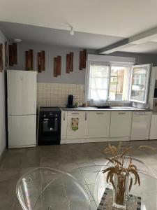 a kitchen with white appliances and a glass table at Maison agréable de 51 m2 in Cuts +6 photos