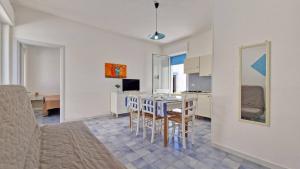 a kitchen and dining room with a table and chairs at Residence La Corte by Salento Affitti in Marina di Mancaversa