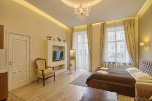a bedroom with a bed and a chair and a chandelier at Taurus Apartments Vilnius in Vilnius