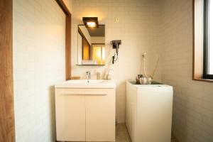 a white bathroom with a sink and a mirror at Hisaya-Totoya-B in Kyoto