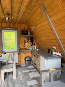 a kitchen in a cabin with a table and a window at Файна хата 3 in Synevyrsʼka Polyana