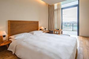 Voodi või voodid majutusasutuse Taihua Wutong Hotel toas