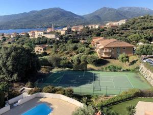 an estate with a tennis court and a house at Appartement avec vue panoramique sur le Golf de Propriano in Propriano