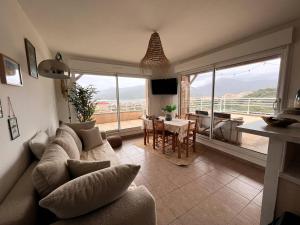 a living room with a couch and a table at Appartement avec vue panoramique sur le Golf de Propriano in Propriano