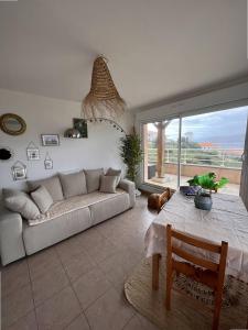 a living room with a couch and a table at Appartement avec vue panoramique sur le Golf de Propriano in Propriano