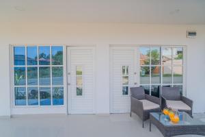 un patio avec deux chaises et une table et des fenêtres dans l'établissement Apartamentos el mochilero Rural la Boquilla, à Carthagène des Indes