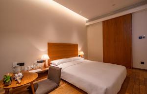Voodi või voodid majutusasutuse Taihua Wutong Hotel toas