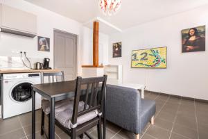 a kitchen and living room with a table and a chair at La salamandre, 2 people, ground floor, free Wi-Fi in Roncq +17 photos