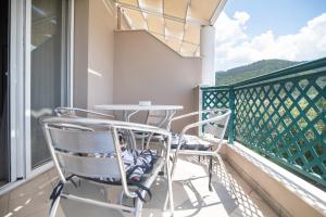 a balcony with two chairs and a table on it at Aegean Sun Hotel in Skala Rachoniou