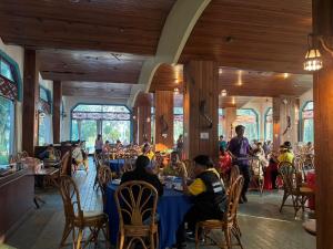 a group of people sitting at tables in a restaurant at Royal Mekong Riverside Hotel in Nong Khai