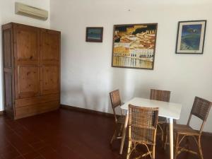 una sala da pranzo con tavolo, sedie e armadio di Vacanze Salina Monolocale vista mare a Lingua