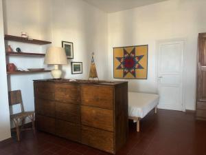 una camera da letto con cassettiera, lampada e sedia di Vacanze Salina Monolocale vista mare a Lingua Altre 7 foto