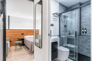 a bathroom with a shower and a toilet and a bed at CC Atocha Apartments in Madrid